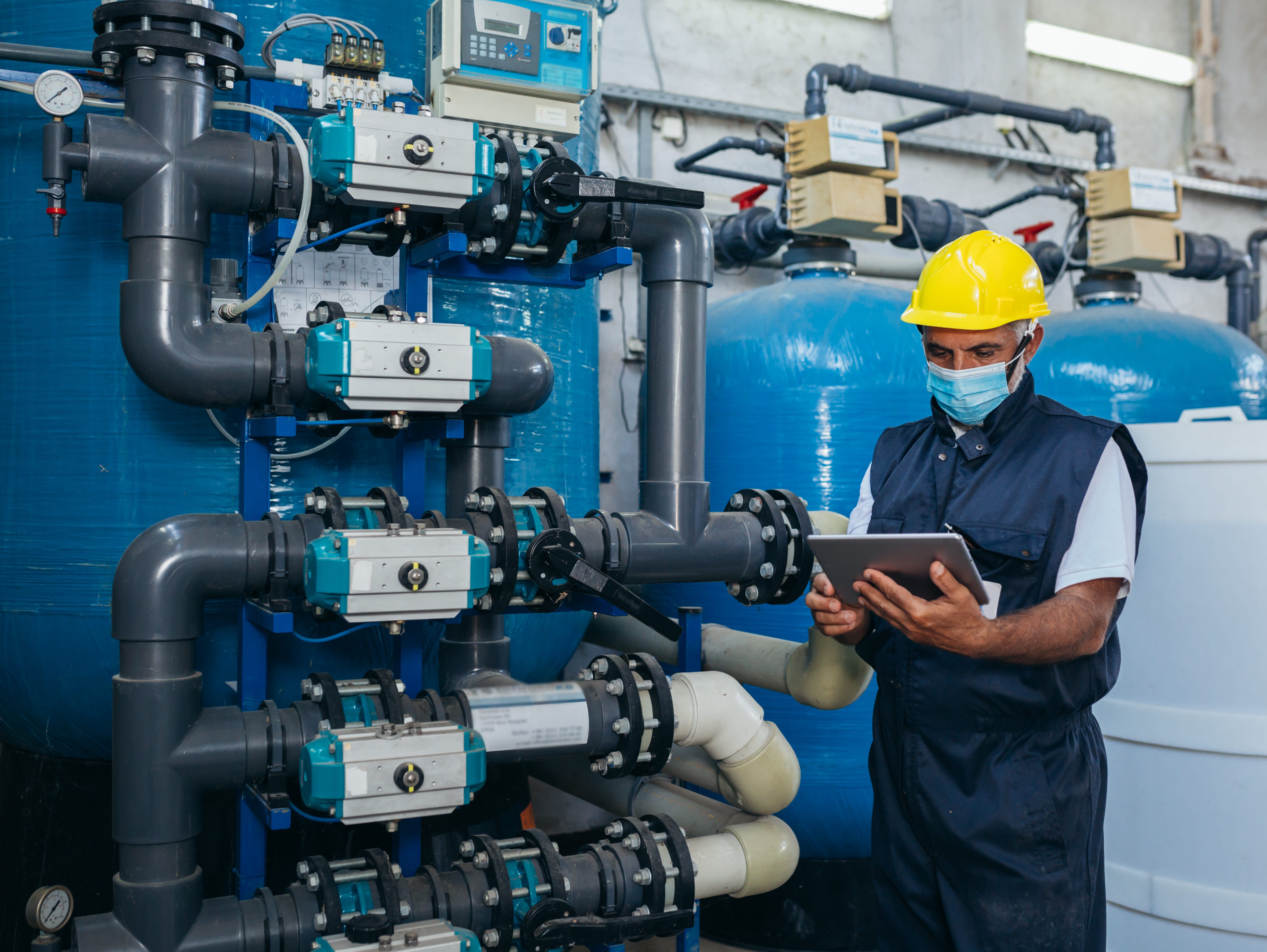 industry worker checking chemical water treatment equipment